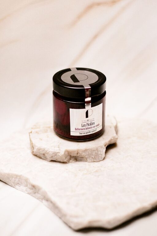 Pot en verre de pickles de betteraves sur une surface en pierre claire.