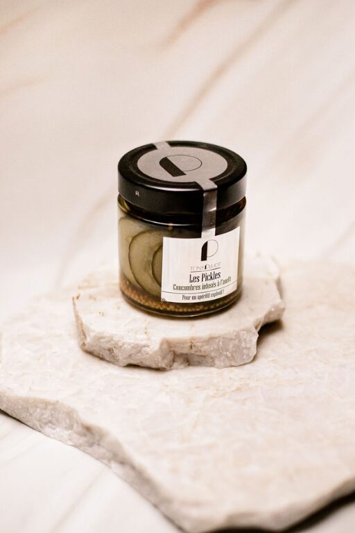 Pot en verre de cornichons tranchés au vinaigre Tonique Loft posé sur plaque en pierre blanche.