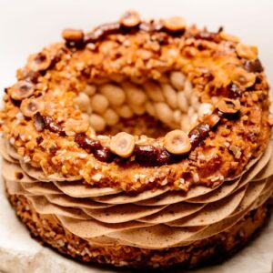 Gâteau en forme d'anneau avec crème au praliné, noisettes entières et éclats croquants.