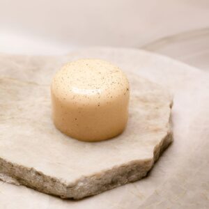 Dessert glacé cylindrique clair avec graines sur plaques de pierre, sans gluten.