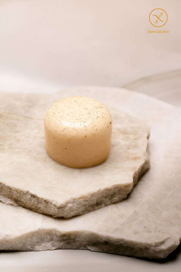 Dessert glacé cylindrique clair avec graines sur plaques de pierre, sans gluten.