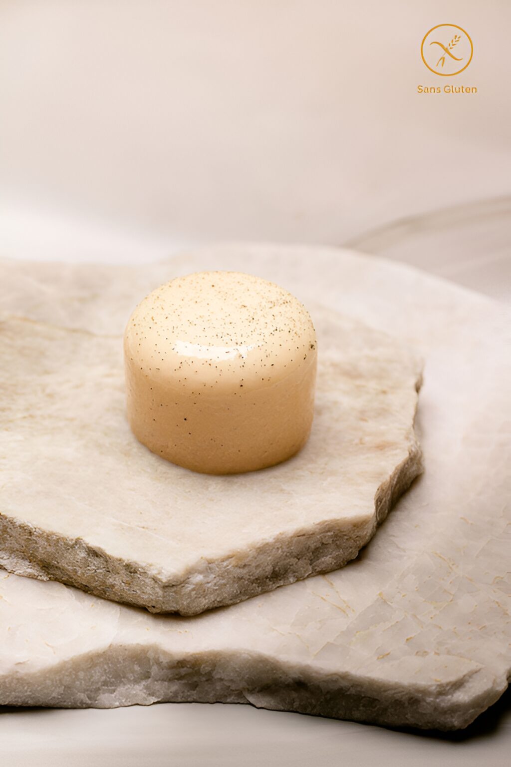 Dessert glacé cylindrique clair avec graines sur plaques de pierre, sans gluten.