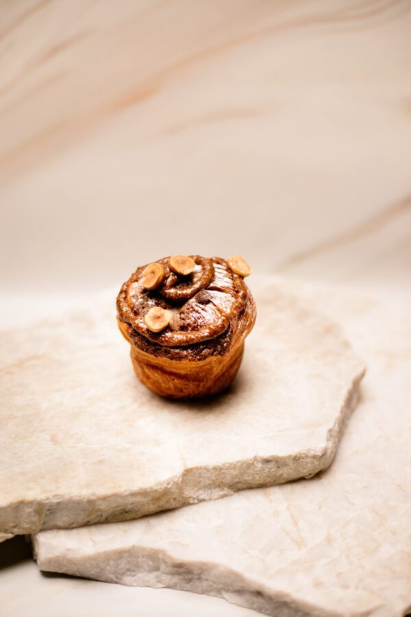 Petit gâteau aux noisettes posé sur des plaques de pierre claire.