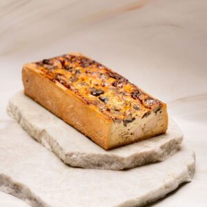 Pain de campagne rectangulaire aux champignons posé sur deux pierres plates en marbre.