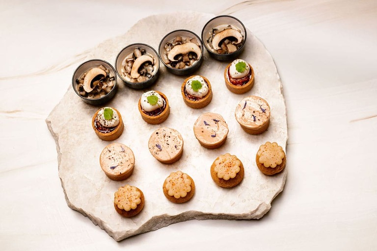Plateau en pierre avec verrines champignons, mini-tartines, pâtés fleuris et biscuits fleurs.