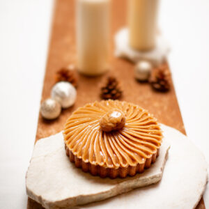 Tarte aux marrons avec crème vanille et insert au cassis sur un marbre blanc