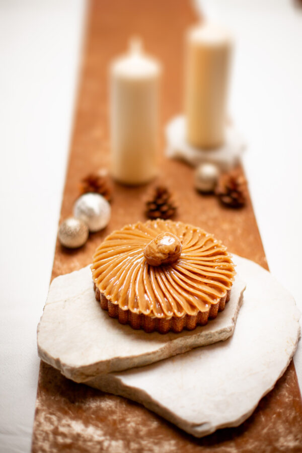Tarte aux marrons avec crème vanille et insert au cassis sur un marbre blanc