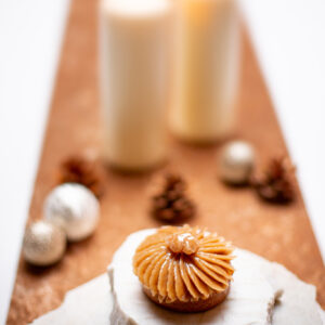 Tartelette aux marrons avec crème vanille et insert au cassis sur un marbre blanc