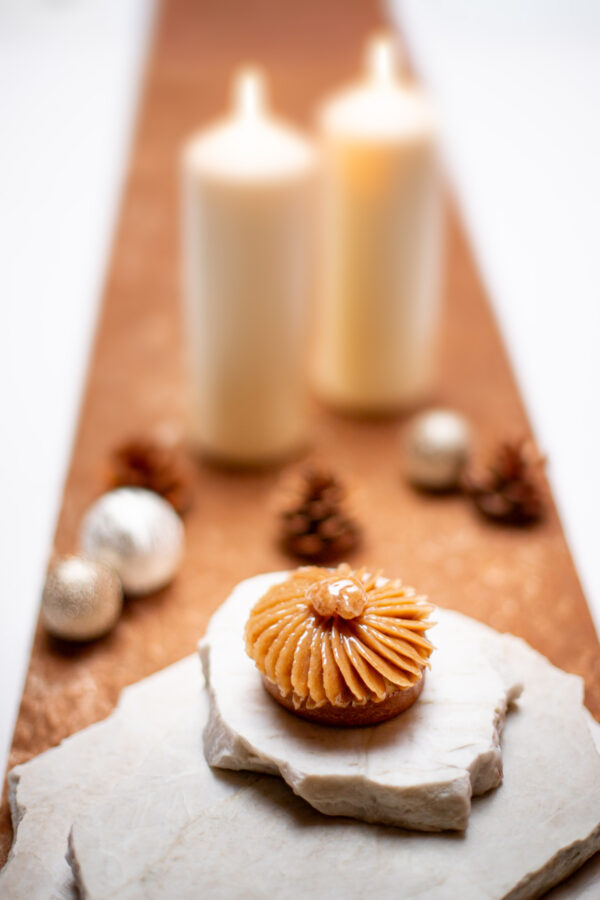 Tartelette aux marrons avec crème vanille et insert au cassis sur un marbre blanc