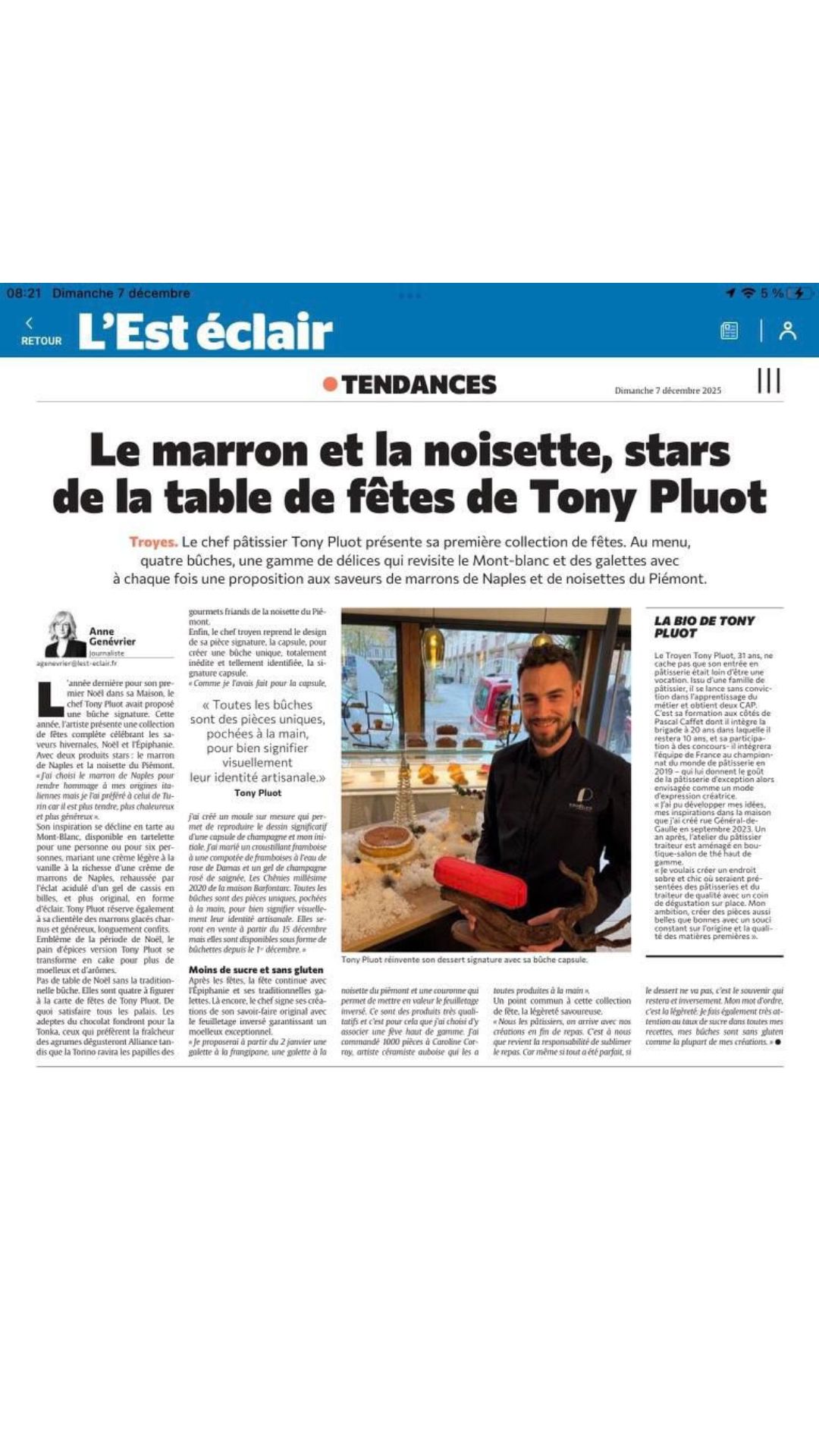 Dessert de Noël sans gluten en forme de bûche de couleur blanches avec des cubes oranges confits posé sur un marbre et un fond doré