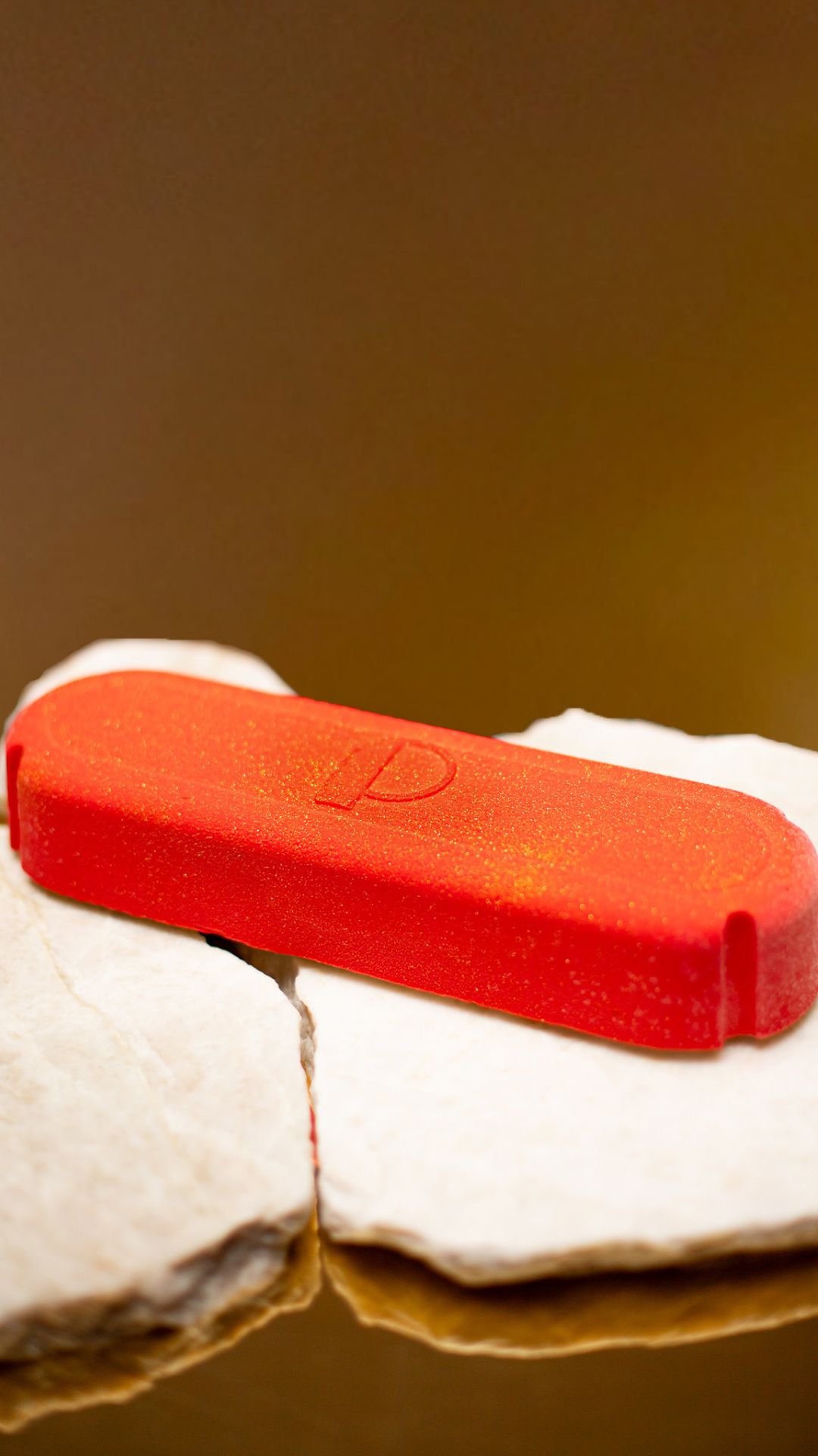 Dessert de Noël sans gluten_en forme de bûche et de capsule de champagne de couleur rouge avec des paillettes dorées sur un support artistique en chocolat sculpté