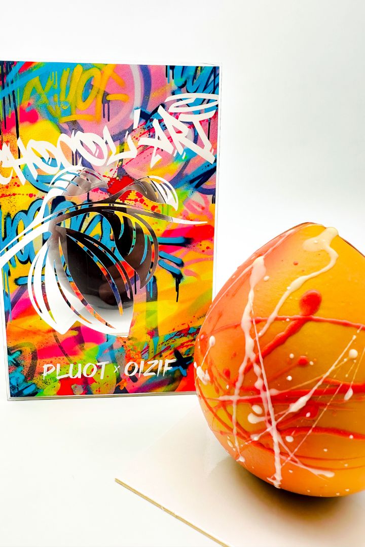 Œuf de Pâques artistique jaune peint à la main devant boîte colorée