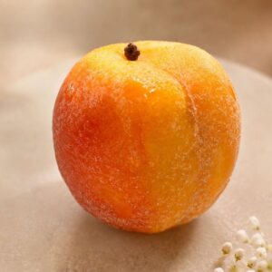 Abricot, fruit de couleur orange jaune et rouge pose sur un marbre