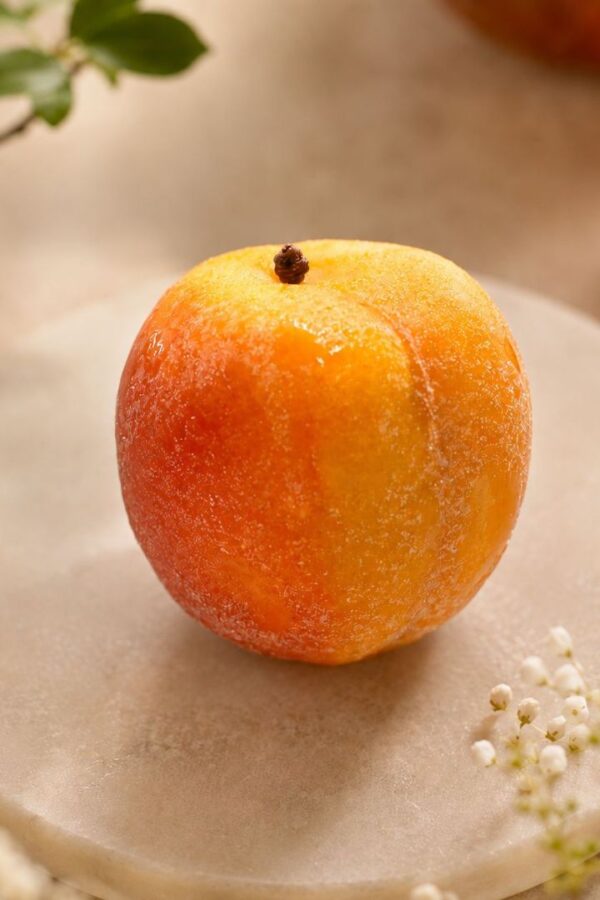 Abricot, fruit de couleur orange jaune et rouge pose sur un marbre